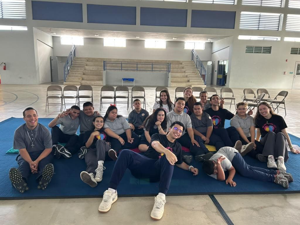 Un grupo sonríe en las colchonetas de un gimnasio